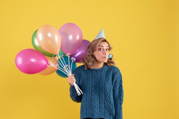 Giovane donna di vista frontale con palloncini colorati