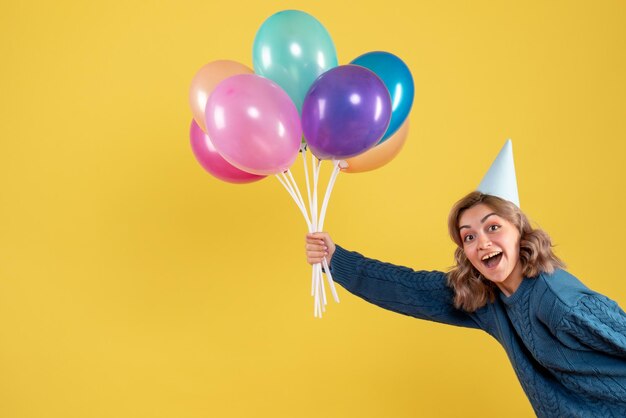 Giovane donna di vista frontale con palloncini colorati