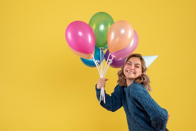 Free photo front view young female with colorful balloons