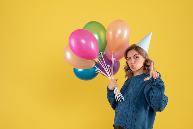 Giovane donna di vista frontale con palloncini colorati
