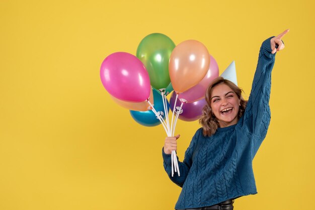 Вид спереди молодая женщина с разноцветными воздушными шарами