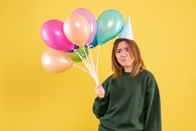 Вид спереди молодая женщина с красочными воздушными шарами