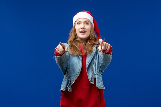 Giovane femmina di vista frontale con l'espressione eccitata sull'emozione blu di natale di festa del fondo