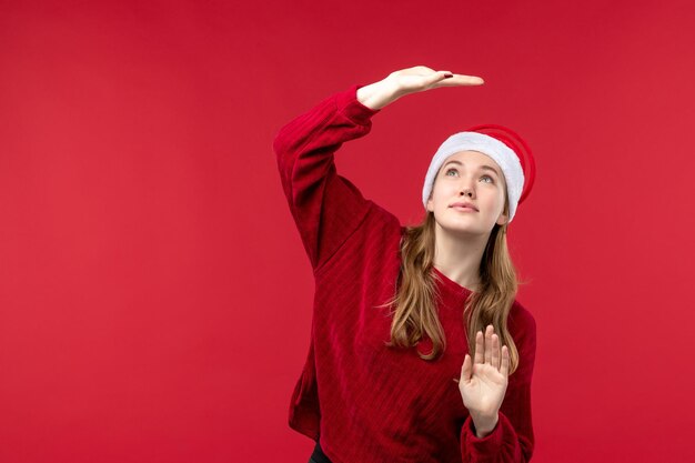 Вид спереди молодая женщина с возбужденным выражением лица, красные рождественские каникулы