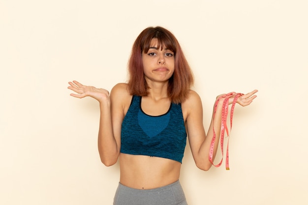 Free photo front view of young female with fit body in blue shirt posing on light-white wall