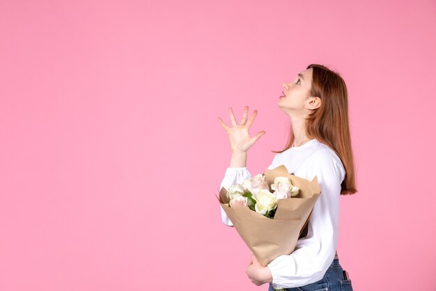 분홍색 배경에 여성의 날 선물로 꽃과 전면보기 젊은 여성 가로 여성 3 월 사랑 관능적 인 날짜 평등 장미