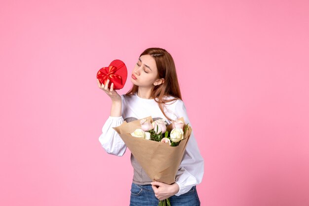 Вид спереди молодая женщина с цветами и подарок на женский день на розовом фоне горизонтальное марш-равенство женское свидание роза любовь чувственная