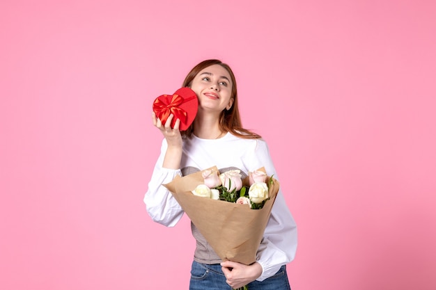 花と正面図ピンクの背景に女性の日の贈り物として提示水平行進平等女性の日付バラの女性の官能的な愛