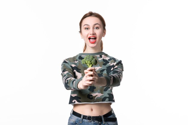 Vista frontale giovane femmina con broccoli verdi su sfondo bianco dieta salute alimentare insalata orizzontale pasto corpo pranzo piatto Foto Gratuite