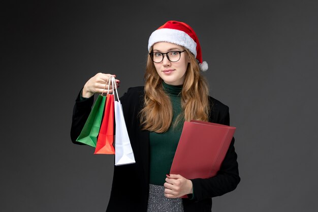 暗い壁の新年の贈り物のクリスマスに休日のプレゼントと正面図若い女性