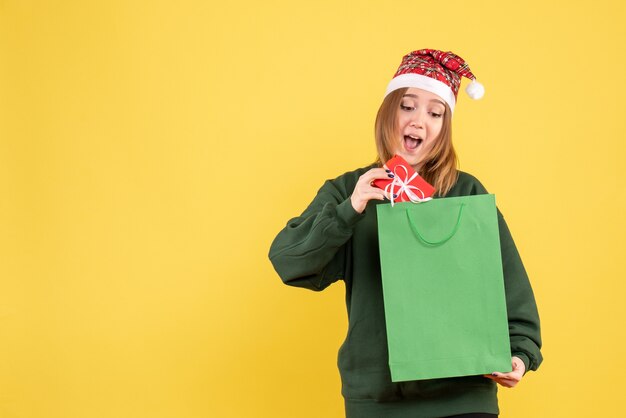 Front view young female with little present and shopping package