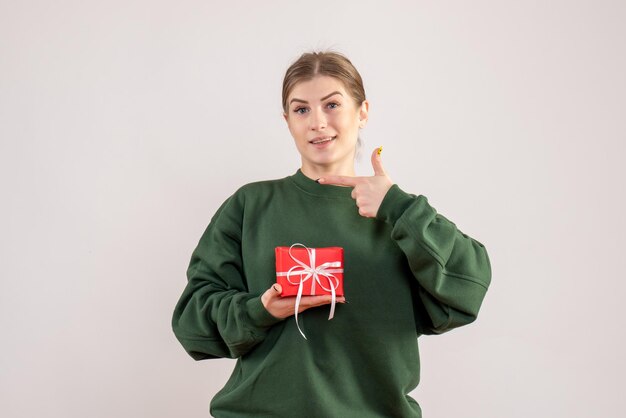 Вид спереди молодая женщина с маленьким подарком на рождество