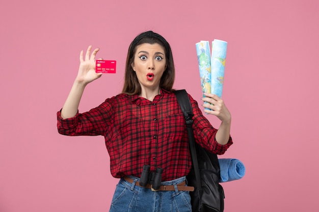 Front view young female with maps and bank card on pink background woman human color