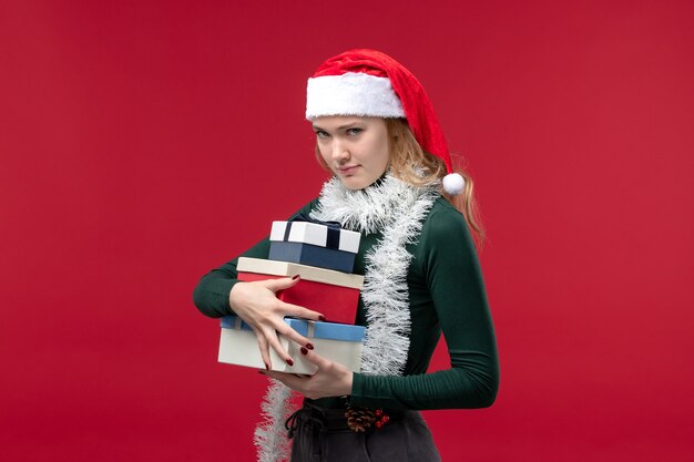 Front view young female with new year presents on red background