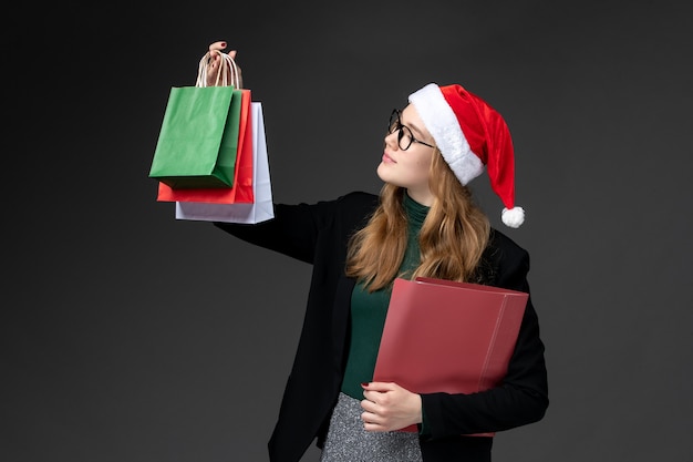 Front view young female with packages on dark wall gifts new year christmas