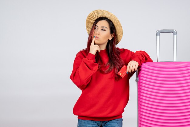 Front view young female with pink bag holding bank card thinking on white wall