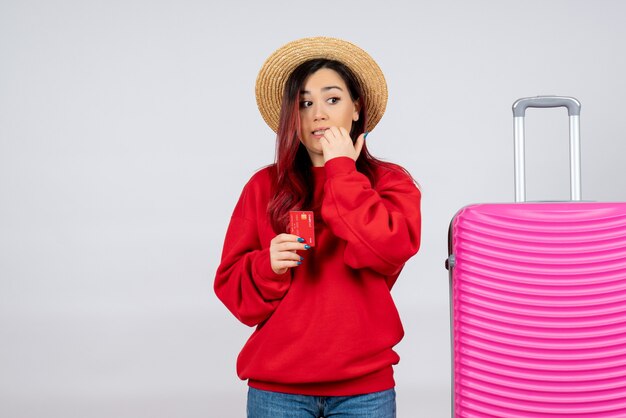 Front view young female with pink bag holding bank card on white wall