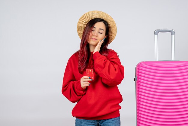 Front view young female with pink bag holding bank card on white wall