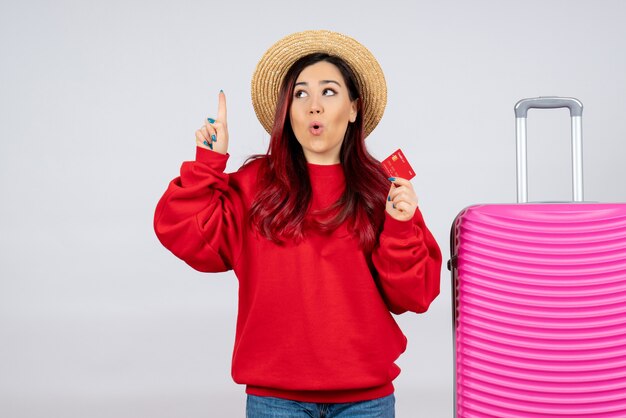 Free photo front view young female with pink bag holding bank card on white wall