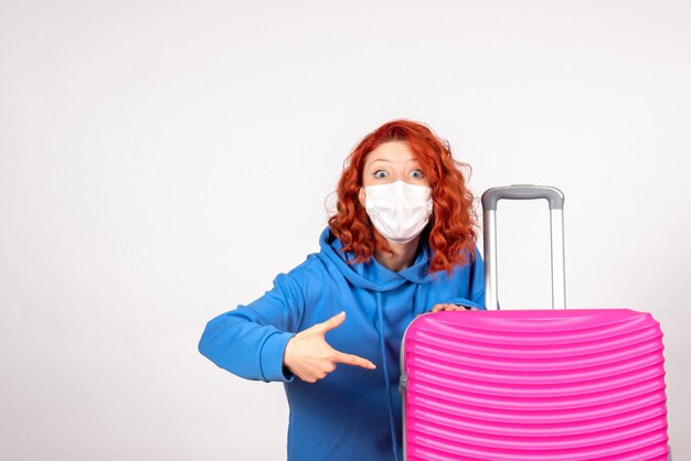 Front view of young female with pink bag on white wall