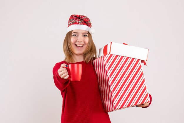 Front view young female with present and cup of tea