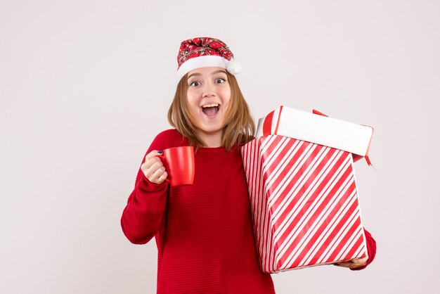 Front view young female with present and cup of tea