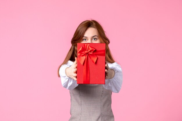 ピンクの背景に赤いパッケージでプレゼントと正面図若い女性愛の日付行進水平官能的なギフト香水平等女性写真お金