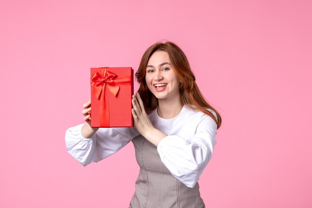 Front view young female with present in red package on pink background love date march horizontal sensual gift perfume woman photo money