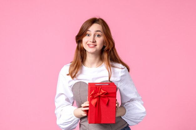 Front view young female with present in red package on pink background love date march horizontal sensual gift woman photo money equality