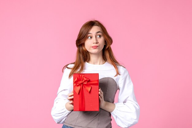 Front view young female with present in red package on pink background love date march horizontal sensual perfume woman photo money equality