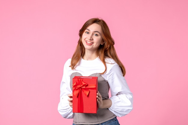 Front view young female with present in red package on pink background march horizontal sensual gift photo money equality woman