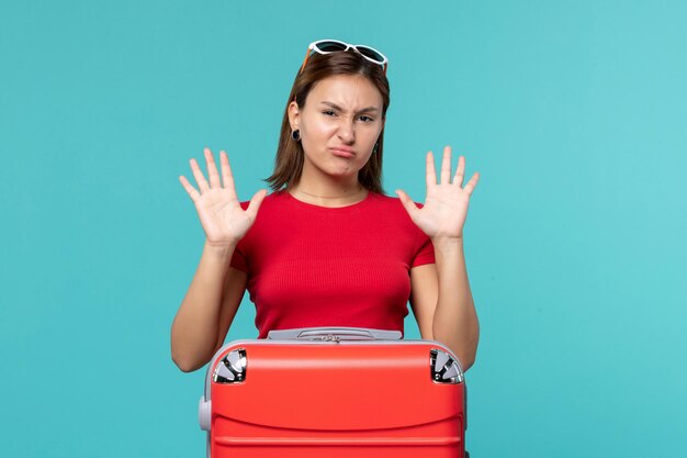 Front view young female with red bag getting ready for vacation on a blue space