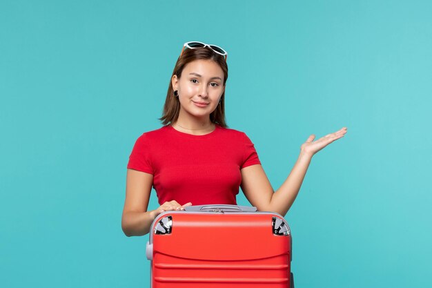 Front view young female with red bag getting ready for vacation on blue space