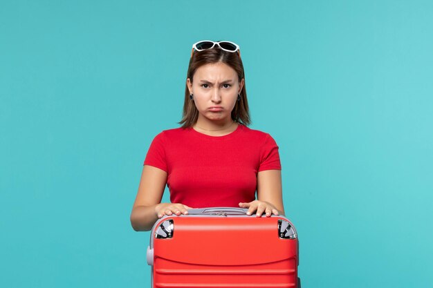 Front view young female with red bag getting ready for vacation on the blue space