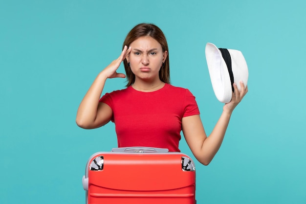 Front view young female with red bag holding her hat on blue space