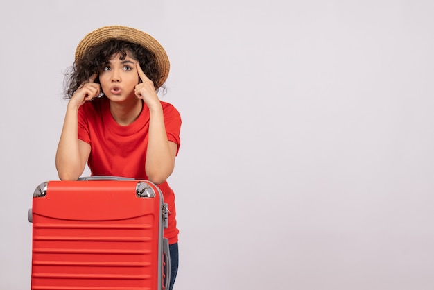 Front view young female with red bag preparing for trip on white background rest vacation color tourist flight plane voyage