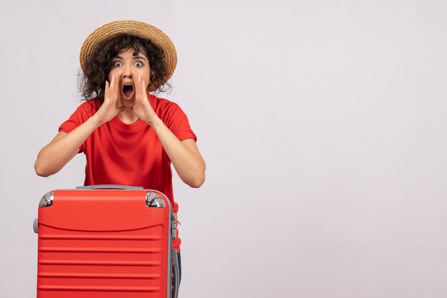 Вид спереди молодая женщина с красной сумкой, готовящаяся к поездке на белом фоне, отдых, отпуск, цвет солнца, рейс, самолет, рейс