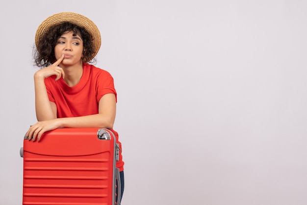 빨간색 가방 흰색 배경 나머지 휴가 태양 색상 관광 비행 비행기 항해에 여행을 준비하는 전면보기 젊은 여성