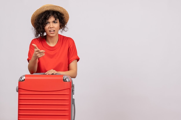 Front view young female with red bag preparing for trip on white background vacation sun color voyage rest flight plane