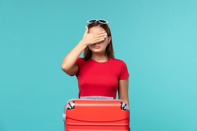 Front view young female with red bag preparing for vacation on a blue space