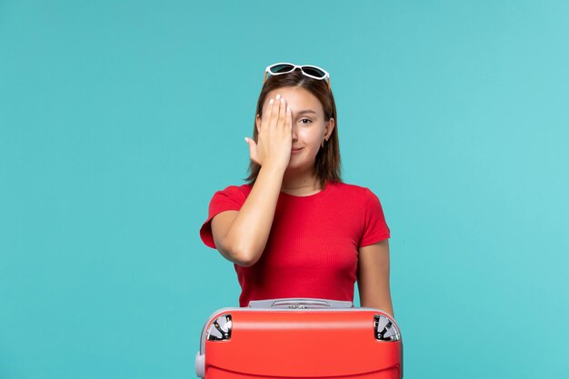 Front view young female with red bag preparing for vacation on the blue space