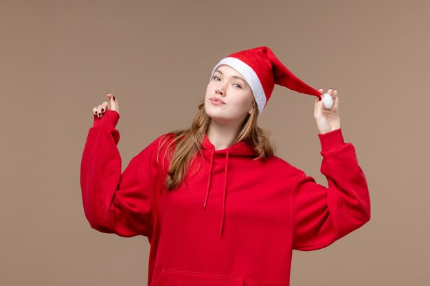 Вид спереди молодая женщина с красной накидкой на коричневом фоне рождественские эмоции праздник
