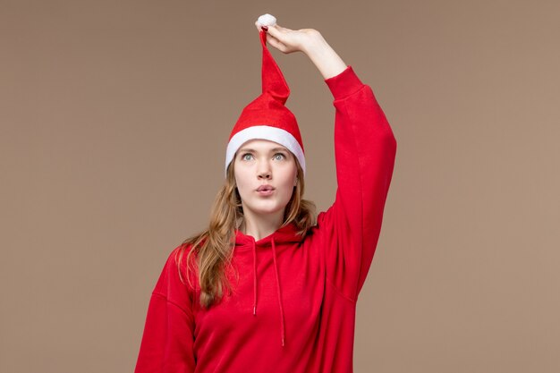 Вид спереди молодая женщина с красной накидкой на коричневом фоне рождественские эмоции праздники