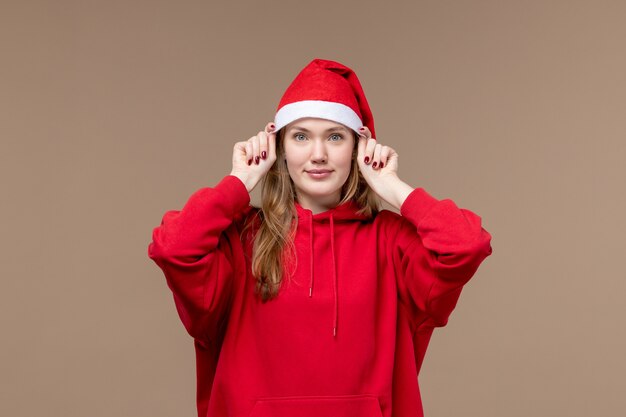 Front view young female with red cape smiling on brown background christmas emotion holiday