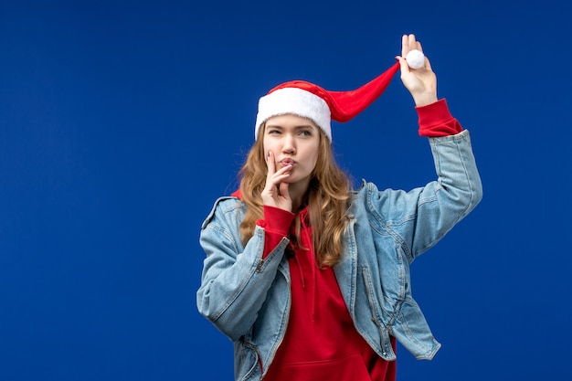 正面図青い背景の上の赤いクリスマスキャップと若い女性クリスマス色の感情