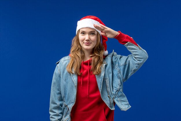 Front view young female with red christmas cap on blue background emotion christmas color