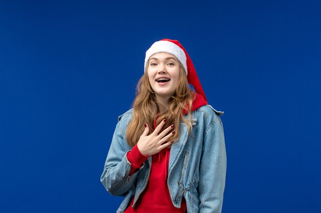 Front view young female with red christmas cap on blue background emotion christmas holiday