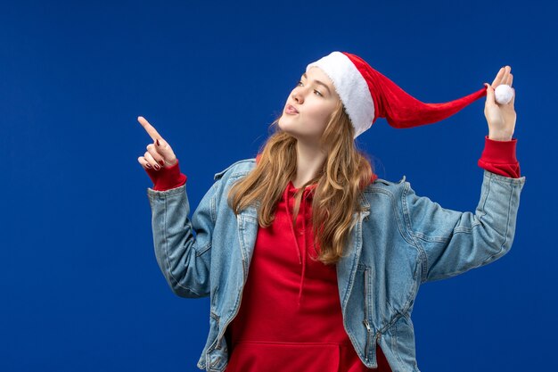 Front view young female with red christmas cap on a blue space