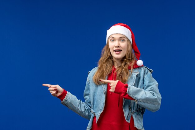 Front view young female with red christmas cap on a blue space