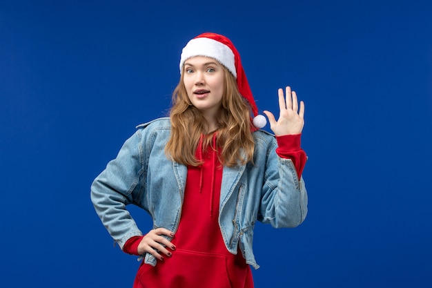 正面図水色の背景に赤いクリスマスキャップの若い女性感情クリスマス色